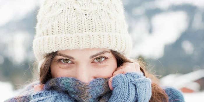 Comment protéger votre peau en hiver person wrapped in a scarf outdoors