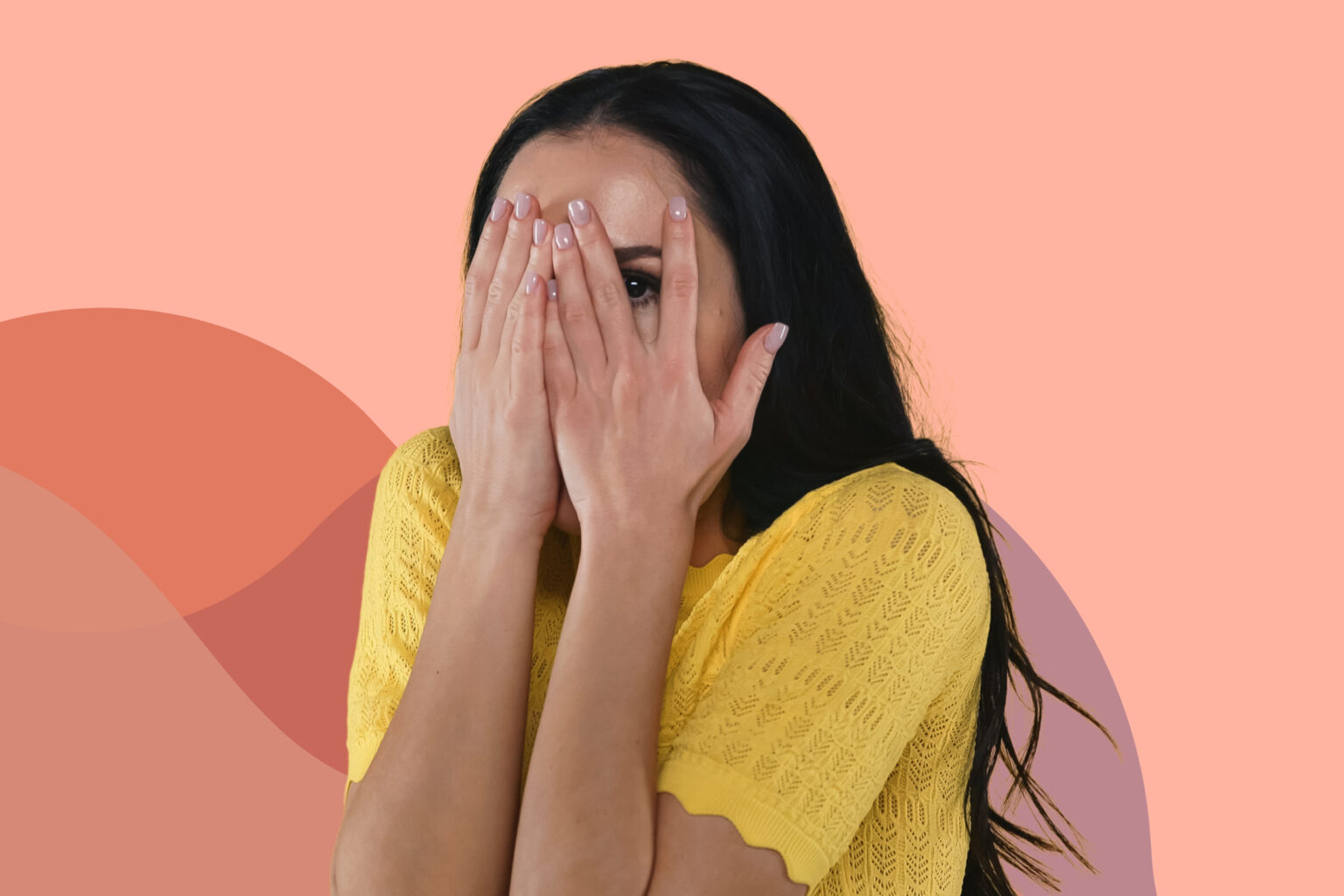 woman covering eyes with hands while peeking through fingers