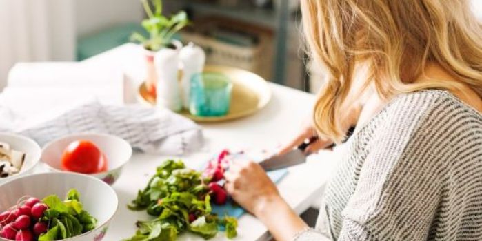 A woman chopping up a salad