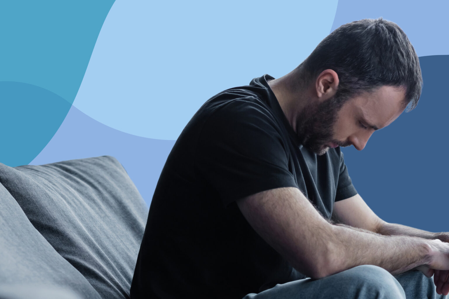 man sitting looking down sad