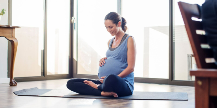 Conseils pour faire de l’exercice en toute sécurité pendant et après la grossesse pregnant woman doing yoga