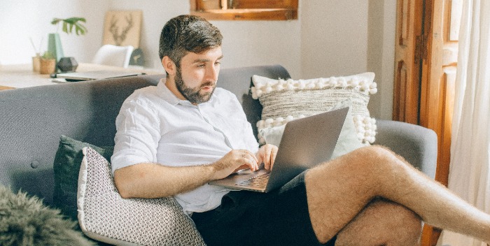 person sitting on a sofa with laptop in hand