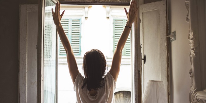Sueurs nocturnes et troubles du sommeil après la ménopause A woman is stretching in front of a window
