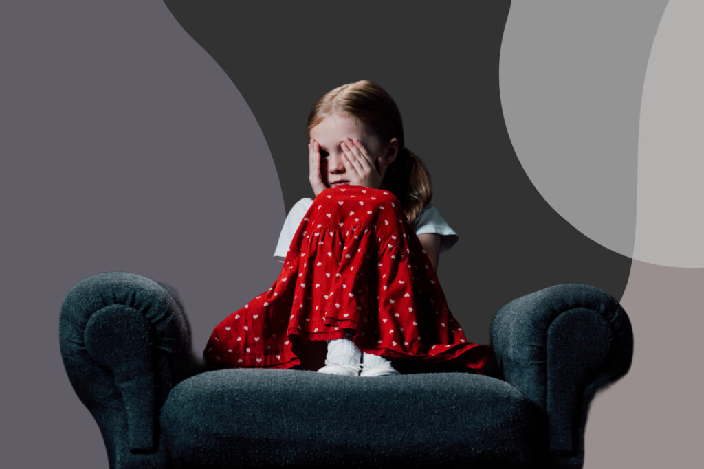 girl sitting on couch burying face into hands