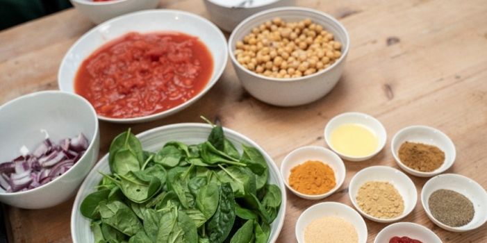 bowls of tomato, spinach, chickpeas, onions and spices