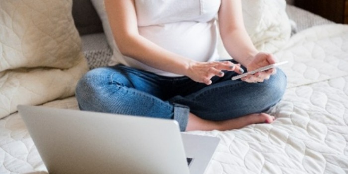 Quels sont les types de soins prénatals qui vous sont proposés pendant la grossesse ? pregnant woman on the phone in bed