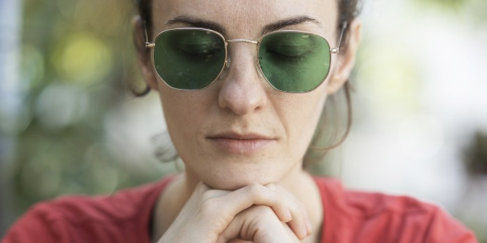 Tired adult with eyes closed sitting outdoors