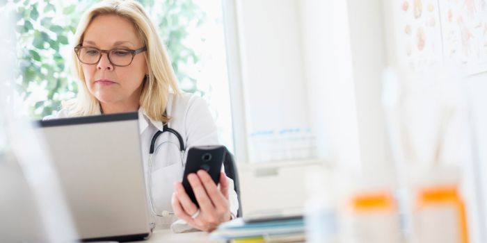 female doctor on a phone and laptop