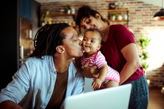 parents kissing a baby