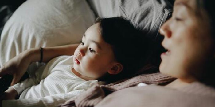 person and child lying in bed