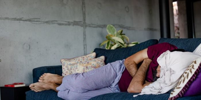 person sleeping on a blue sofa
