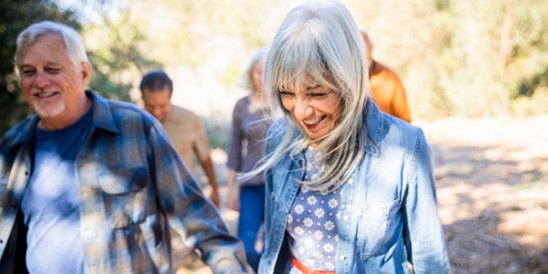 group of people smiling and walking outdoors