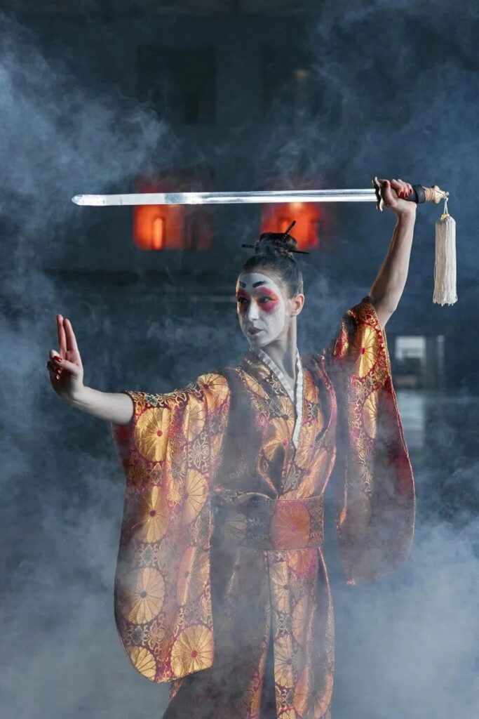 Tsurugaoka hachiman-gu reitaisai à kamakura 2025: un spectacle historique de samouraï Dramatic samurai cosplay featuring a woman in kimono wielding a katana amidst smoke.