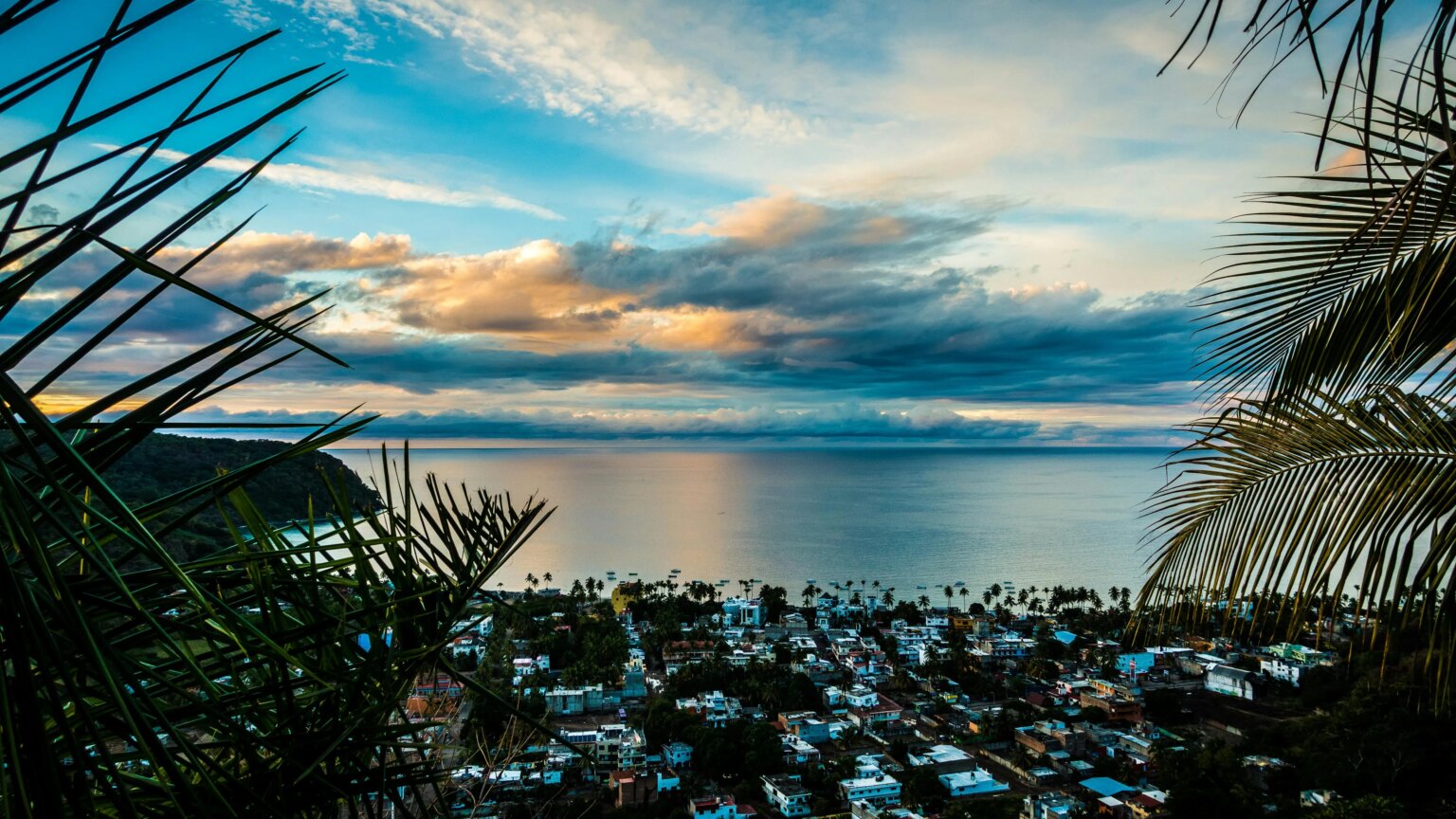 Dramatic coastal sunset painting the sky in orange and blue hues above Puerto Vallarta