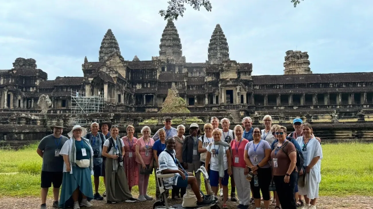 Temple d'Angkor Wat avec un groupe de touristes posant devant lors d'un voyage près de Siem Reap, au Cambodge.